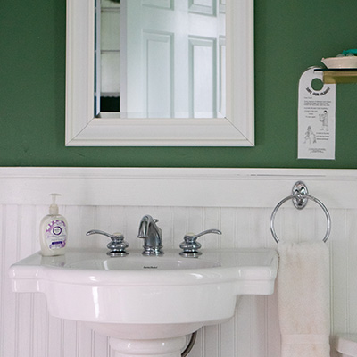Mirror above a white pedestal sink